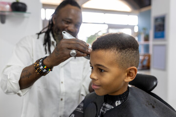 Young biracial boy having his haircut