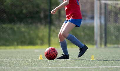 Girl Skillfully Dribbles Ball Between Flip Cups During Football Practice, Captured In Close-Up,...