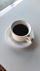 Black coffee in a white cup and a white table.