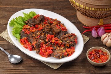 Dendeng balado or dendeng batokok is a typical Padang dish in the form of thin slices of beef fried crispy, then topped with balado seasoning.