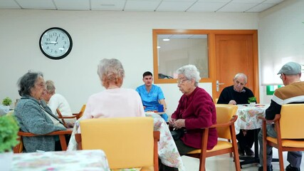 Elderly people playing cards and socializing in nursing home - Powered by Adobe