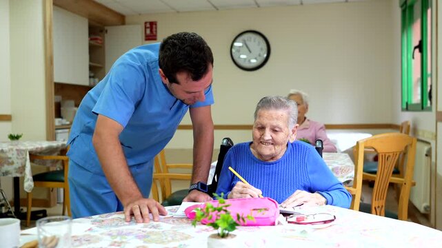 Nurse assisting elderly woman with writing in nursing home