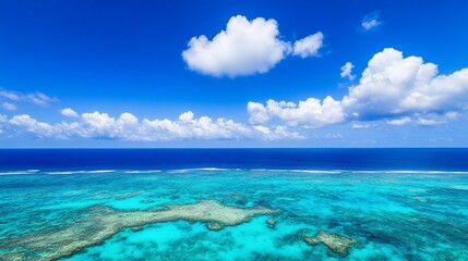 Fototapeta premium Aerial view vibrant coral reef, ocean, sunny sky, clouds, tropical island