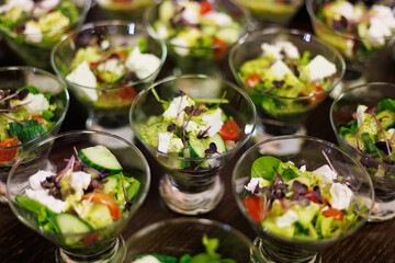 Colorful mini salads with fresh vegetables, feta cheese, and microgreens, beautifully served in elegant glass cups for a refreshing and healthy appetizer
