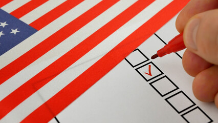 Red marker marks box next to candidates name on ballot. Democratic elections in USA. National flag...
