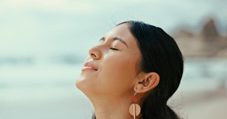 Happy woman, relief and relax with fresh air at beach for peace, tranquility or natural meditation. Female person, vacation or holiday with smell at ocean coast for calming sensation or mindfulness © peopleimages.com