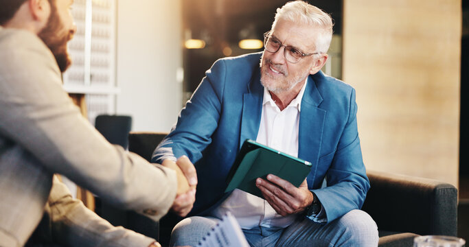 Business people, mature or CEO shaking hands for negotiation, agreement or b2b deal in lobby. Tablet, executive director or entrepreneur greeting investor for handshake offer, partnership or meeting