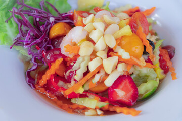 This fruit som tam combines shrimp, strawberries, corn, tomatoes, and macadamia nuts for a refreshing, sweet, and savory Thai-style salad.