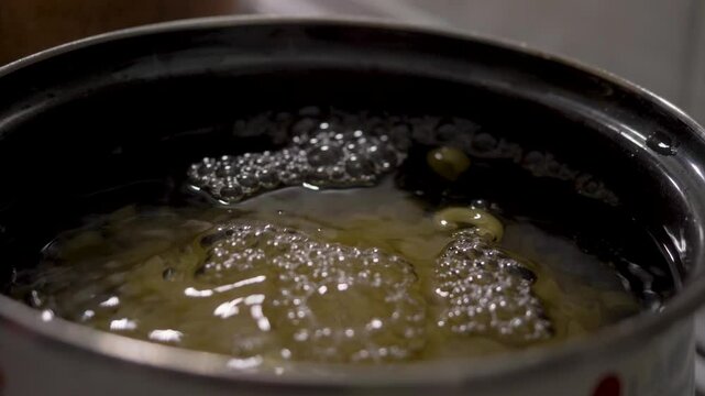 Boiling water in pot on stove receives short pasta. Steam rises as it softens in heat. Basic yet vital step in cooking dishes ranging from light salads to rich entrees