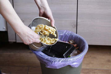 Person Throwing Leftover Pasta Into Trash Bin. Compost from leftover food, Environmentally Responsible