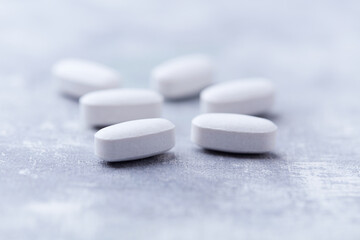 Amino acids tablets on wooden background. Soft focus. Close up	