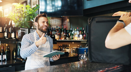 Man, store and thumbs up for delivery at restaurant with smile for courier service, food or sale at diner. People, server or happy waiter with tablet, order or bag in meal with small business owner