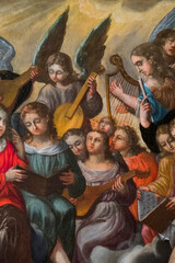 Fototapeta premium Painting (19th century) of a group of musician angels in the sky playing music.