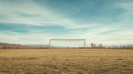 lonely soccer goal on empty field under blue sky