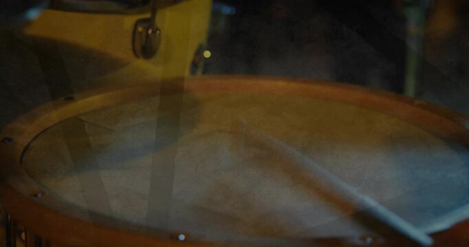Drum head spinning slowly in 3D render, wooden rim glowing warmly, mallet resting under cymbal