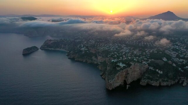 Aerial time lapse over the clouds in La Nao Cape lighthouse, in Javea, Mediterranean Sea, Spain.