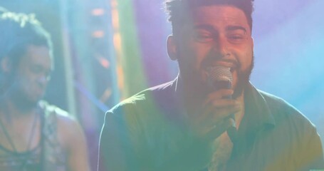 Male vocalist leaning into microphone under colorful stage lights, displaying animated audio waves - Powered by Adobe