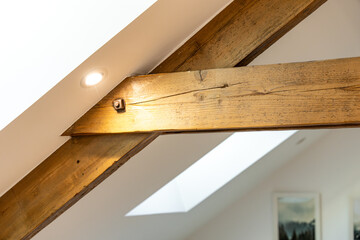 Charpentes en bois apparentes dans une pièce de vie chaleureuse, mêlant authenticité, volume et architecture intérieure de caractère.
