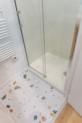 Douche moderne avec parois vitrées et robinetterie design, illustrant un espace de bain élégant...