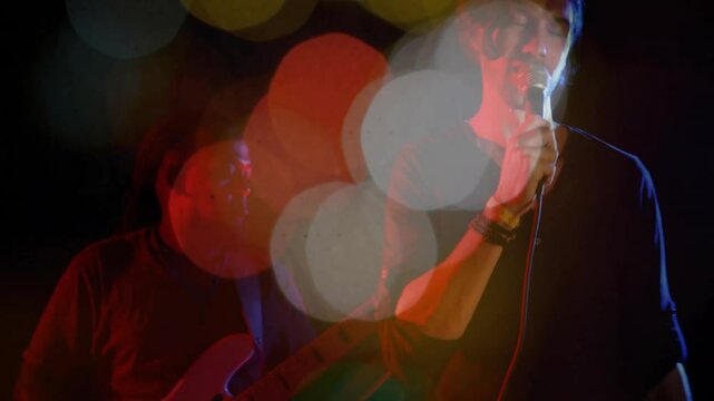 Lead singer singing into microphone on stage, with animated music equalizer bars and light flares