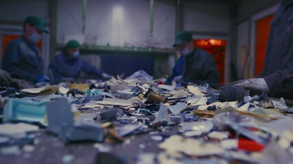 Man sorts garbage, electronics or plastic. Taking care of the environment. Waste recycling plant or garbage factory. Conveyor belt, trash moving along the line. Male have a eco-friendly work