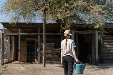 Young Woman Gardener Holding Watering Can on a Sunny Farm Day