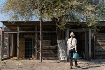Young Woman Gardener Holding Watering Can on a Sunny Farm Day