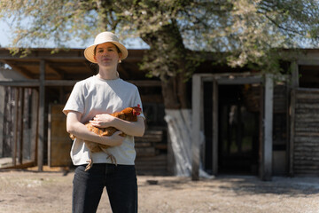 young woman in a straw hat holding a chicken