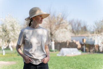 young woman in a straw hat standing in the garden