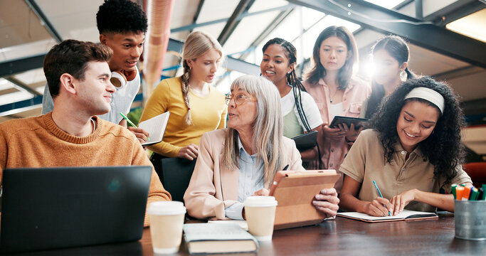 Education, students and lecturer with tablet, talking and info for assignment in classroom and group. Happy, teacher and mature woman with advice for project, people and notes with tech in university