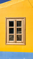 Wooden Window On A Bright Yellow And Blue Wall In Kastellorizo Island, Greece, On A Sunny Day, Concept Of Minimalist Architecture, Summer Vibes, Travel Inspiration, Mediterranean Style, Colorful Desig