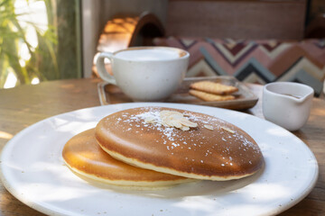 Fluffy Homemade Pancakes with Coffee and Cookies - Cozy Sunlit Breakfast on Wooden Table. Minimalist Brunch Aesthetic