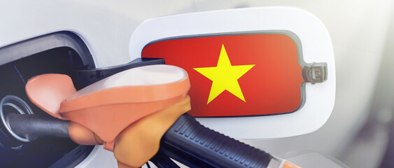 Vietnam flag on the lid of the gas tank of a car at a gas station in close-up. High or low gasoline...