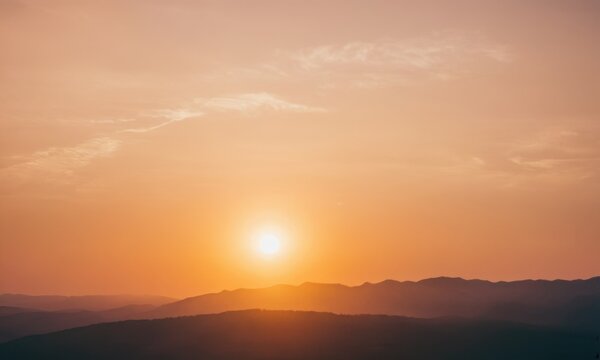 Sunset over a mountain range with mountains and sky
