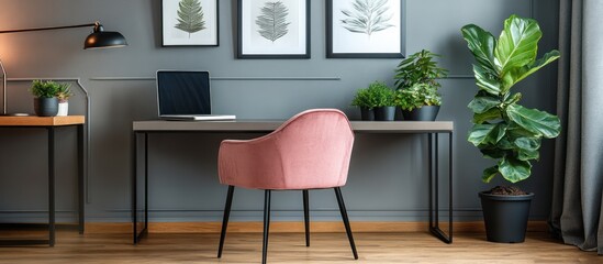 Modern home office workspace with plants and a blush pink chair