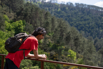 young man hiking walking around green mountains nature in sunny weather looking at the view europe