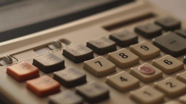 Close-up, finger pressing calculator buttons, financial indicators calculation, budget planning concept
