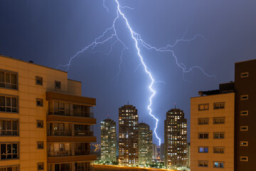 Image of lightning shower illuminating the surroundings in the dark of the night.