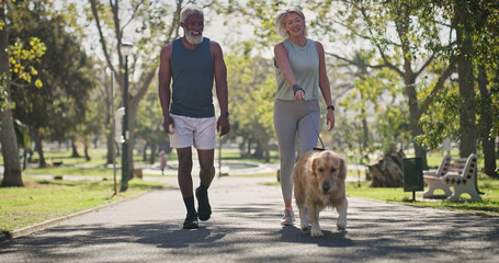 Park, couple and happy for walking with dog for fitness, exercise and workout for health. Outdoor, interracial and mature people in relationship with pet or animal for support, care and bonding