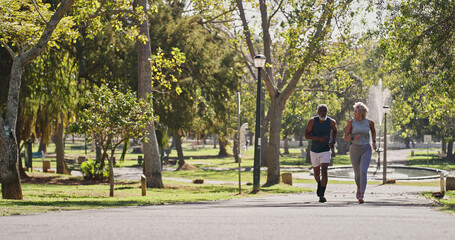 Fitness, elderly couple and running in park for training, cardio exercise and wellness in retirement. Senior interracial people, smile outdoor or workout support, motivation or friends with energy