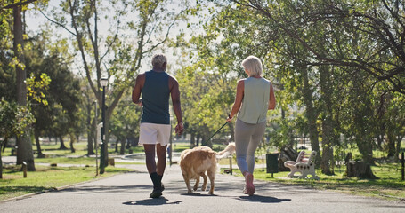 Park, couple and walking with dog for fitness together as exercise, workout and health as lovers. Outdoor, back and mature people in relationship with pet or animal for support, care and bonding