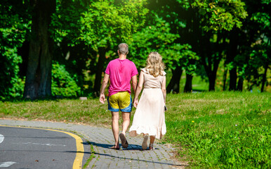 Obraz premium A man and a woman walk in a summer park 