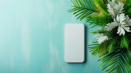 A smartphone rests against a blue surface adorned with tropical leaves, visually combining modern technology with natural elements for a fresh, dynamic appeal.