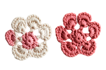 Two crocheted cat paw prints, in pink and cream colors on a transparent background