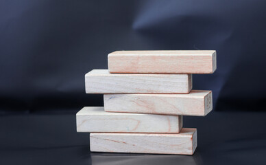 Five blank wooden blocks stacked on a blurred background.