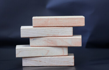 Five blank wooden blocks stacked on a blurred background.