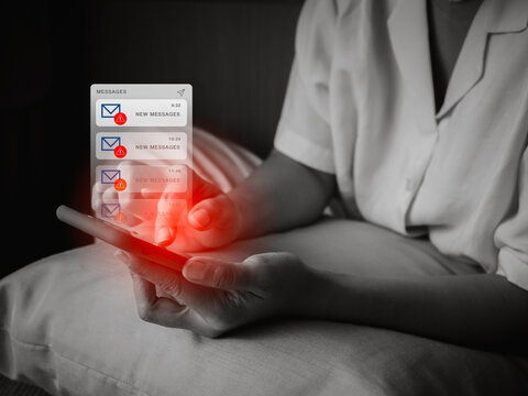 SMS spam and fake text message phishing concept. System hacked warning alert, email hack, scam malware spreading virus alert on messages application on mobile smart phone screen in woman hands.