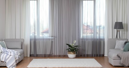 Windows with stylish curtains in living room interior
