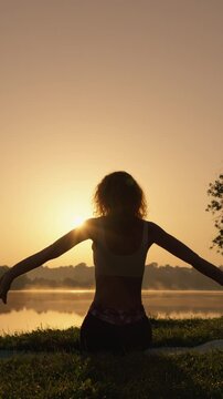 A tranquil and picturesque scene unfolds as a person peacefully meditates by the serene lakeside at sunrise, beautifully embodying calmness and a profound connection with the natural world