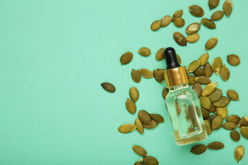 Pumpkin seed oil on mint background. Top view